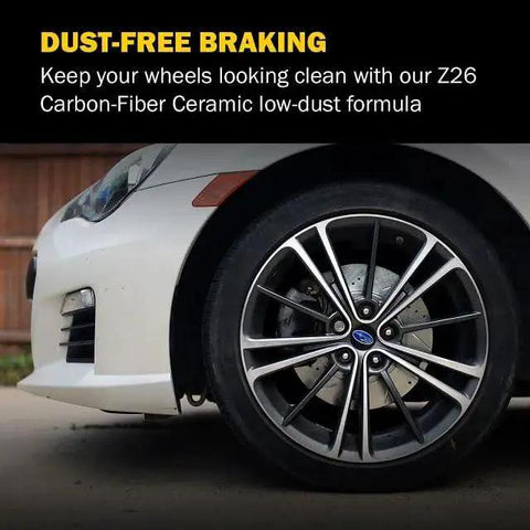 PowerStop front brake pads on a white car front wheel with visible rotor and caliper.