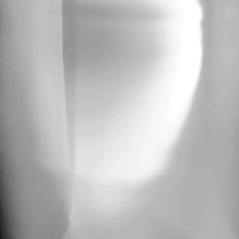 Abstract light and shadow on a wall, showcasing a soft, atmospheric gradient effect.