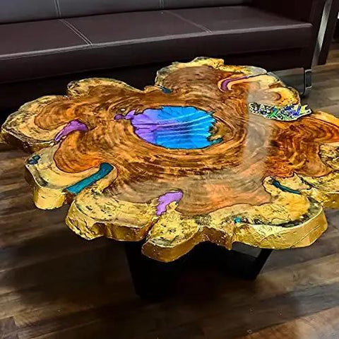 Wooden river table with vibrant resin inlay on a polished slab, showcasing natural wood grain and blue resin accents in a living room.