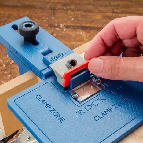 Corner Key Doweling Jig for Decorative Mitered Joints With Molded Reference Lines and Drill Guides in use on wood surface