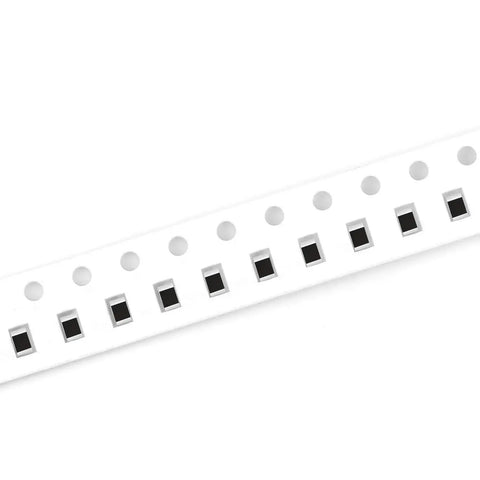 Angled side view of SMD 0805 resistor tape on white carrier strip with black chip resistors.