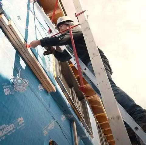 Worker installing Pump Jack Brace 2201 OSHA Compliant Triangular Bracing Swivel Head on ladder at construction site