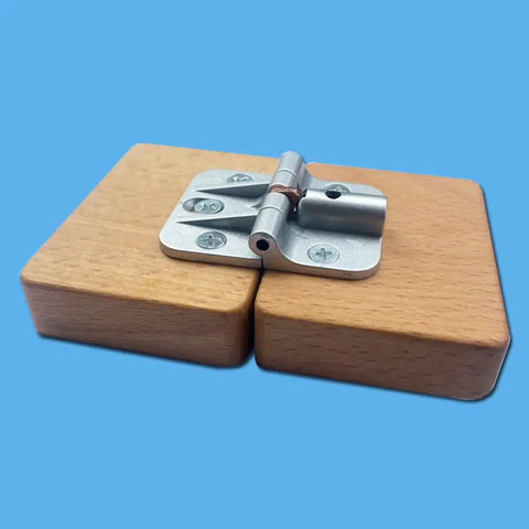 180-degree positioning hinge, silver alloy; close-up view on wooden blocks used for cabinet/table hinge.