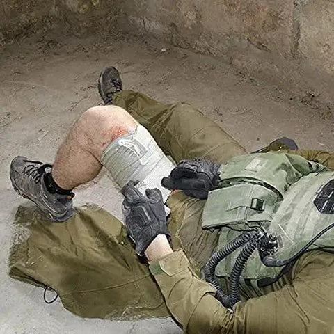 Person using Israeli Style Emergency Bandage 6 Inch Trauma Wound Dressing With Compression on leg in tactical situation.
