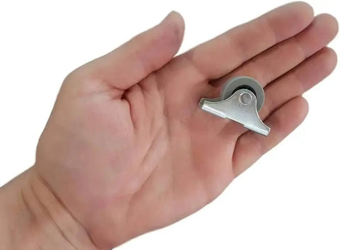 Hand holding single caster from Pack Of 20 25mm Rubber Wheels Set With Metal Plates And Plastic Double Castors For Furniture And Appliances