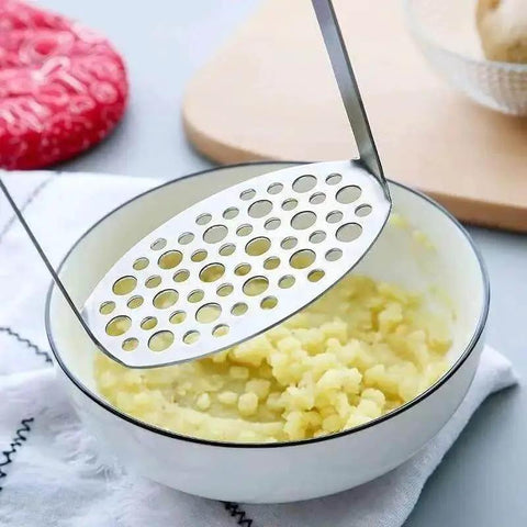 Stainless Steel Potato Masher With Integrated Design And Crinkle Cutter Easy Wide Grip Kitchen Tool for mashing potatoes in bowl.