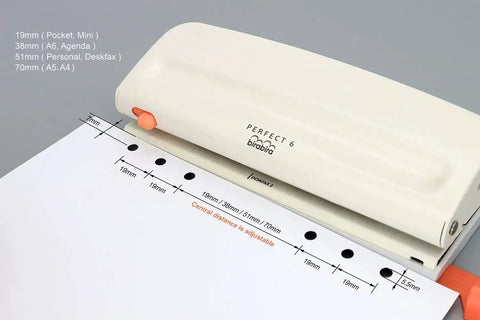 Adjustable Six Hole Punch For Pocket Journals And Planners, 8 Sheet Capacity shown with A4 paper, desktop crafting tool