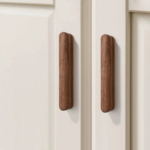 Walnut Wood Drawer Pulls Set Six Pack 5.04 Inch Length With Rounded Edge For Cabinets; two walnut pulls on white cabinet doors
