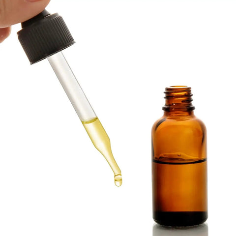 Close-up of a dark amber glass dropper bottle with liquid dropper, part of 4 Pack 30ml Dark Amber Glass Dropper Bottles With 1 Funnel And 4 Labels.