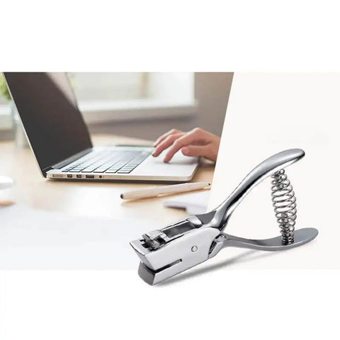 Heavy Duty Single Oval Hole Puncher for Scrapbooking Handheld Paper Cutter with Chrome Finish next to a laptop