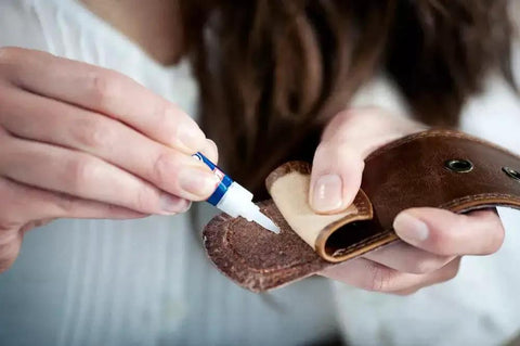Person applying Clear Quick Dry Super Glue For Plastic Wood Metal 2 Pack Precise Piercing Tube to a leather item