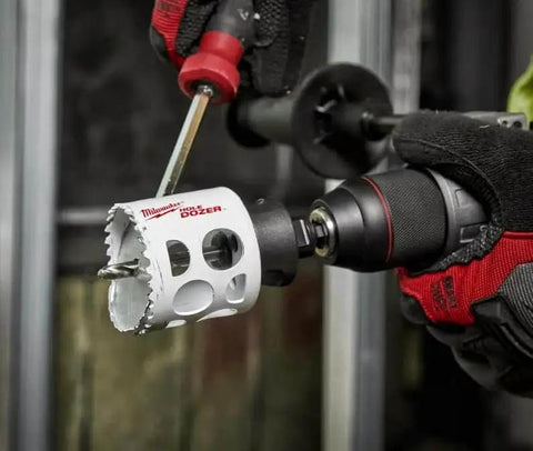 Worker using Ice Hardened Two And A Half Inch Hole Saw For Quick Clean Holes With Matrix II Bi Metal Teeth And Positive Rake Cutting For Fast Durable Performance And Longer Life Manufactured In United States Milwaukee on a drill.