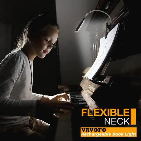 Rechargeable Clip Reading Light With 7 LEDs, 9 Color Temperatures And 9 Levels attached to a book illuminating a piano