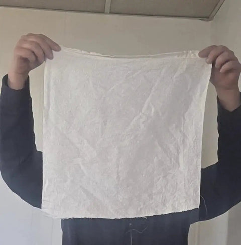 Person holding medical grade white cleaning rag lint free industrial shop towel for mechanics roofing painting