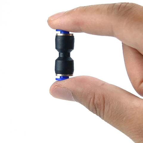 PU4/PC4-M6 pneumatic tube fitting held between fingers; black plastic body with blue end collars.