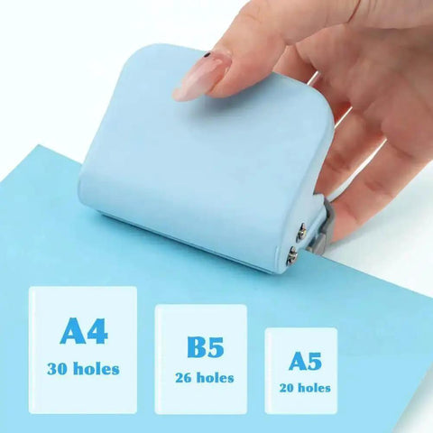 Six Hole Spiral Binding Punch For Planners And Home Office 8 Sheet Capacity in use on blue paper with hand