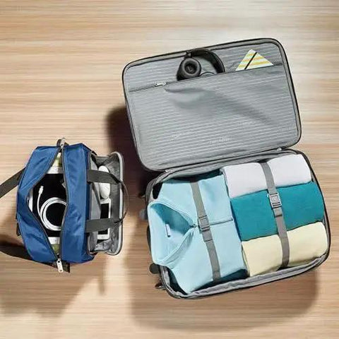 Open view of navy blue Amazon Basics softside luggage set, showcasing packed 23-inch expandable suitcase and 15-inch tote with organized essentials.