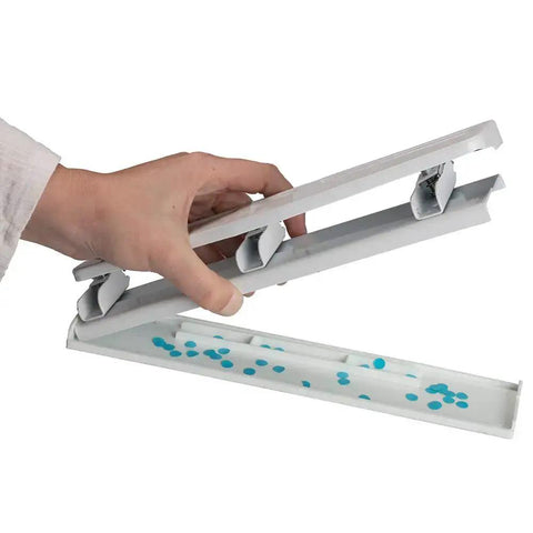 Hand holding open metal 3 hole punch showing underside and paper confetti, Metal 3 Hole Punch For White Paper, 10 Sheet Capacity, Built Tough Desk Side Workhorse
