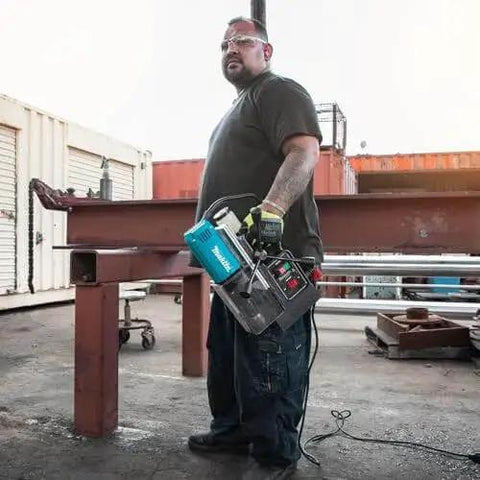 Person holding Portable Magnetic Drill For Steel With One And Three Eighths Inch Capacity And Two Inch Thick Cutting, A Real Workhorse With 850 RPM From A Ten Amp Motor, Lightweight And Compact For Tight Spaces, Removable Guard, Spindle Coolant System Makita HB350 on construction site