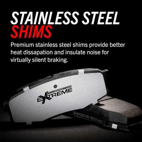 Close-up of front brake pads (pair) with stainless steel shims; gray carbon-fiber ceramic friction surface visible