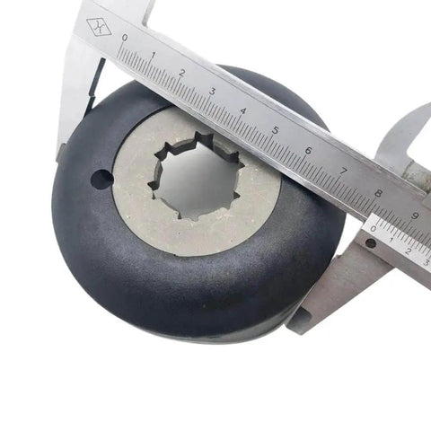 Clutch for Cam Helix, close-up view; black round automotive part with silver central spline, caliper for scale