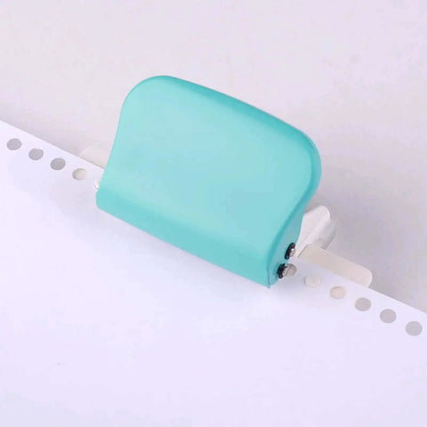 Portable handheld metal circle paper punch with green finish on paper; Handy 6 Hole Puncher For A4 A5 B5 Notebooks And Scrapbooks.