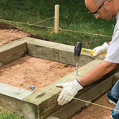 Man installing Heavy Duty 12 Inch Round Metal Landscape And Paver Edging Anchoring Spikes 10 Pack Rock Solid Timber Nails