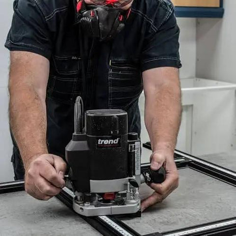 Worker using Adjustable Router Jig Frame and Guide System for Cutting Square and Rectangular Recesses, Slots, and Face Panel Molds