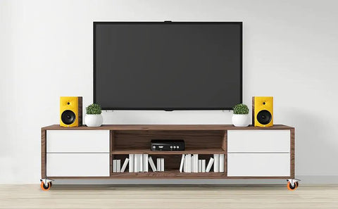 Modern entertainment center with TV, speakers, and books on a stand, showcasing home decor styling.
