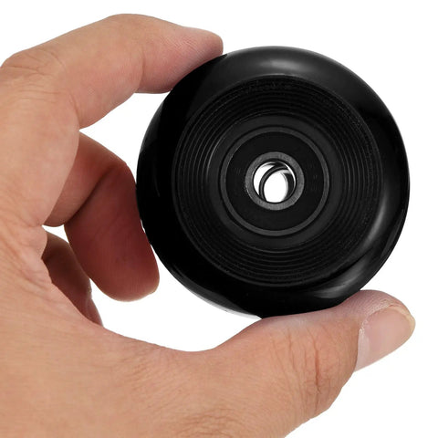 Hand holding a black 54mm skateboard wheel with ABEC 9 bearings, part of the 54mm Skateboard Wheel Set With ABEC 9 Bearings Four Pack Cruiser.