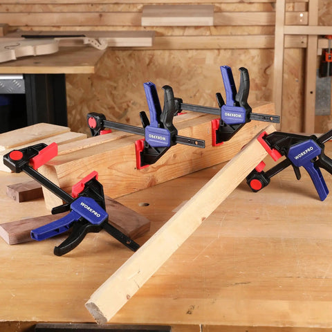 Four WORKPRO 6 Inch Light Duty Bar Clamps holding wood in a workshop, showcasing one hand clamp spreader quick change F clamps setup.