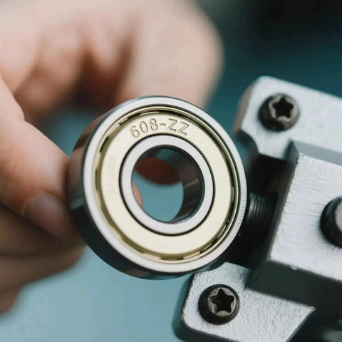 Close-up of 100 Pack 608 ZZ Deep Groove Ball Bearings With Double Metal Shields 8mm x 22mm x 7mm being held next to machinery part.