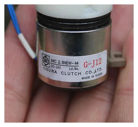 Close-up of a small DC-24V electromagnetic clutch with metal cylindrical housing and Ogura Clutch Co. label G-J12
