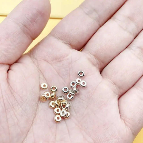 Hand holding 2000 Pcs 4mm Flat Round Disc Spacer Beads For Bracelet And Necklace Making, Silver And Gold Tone CCB Spacers