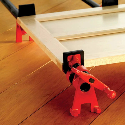 Close-up of a Half Inch H Style Pipe Clamp with clutch disc, acme threaded spindle, and high base on wooden surface for woodworking.