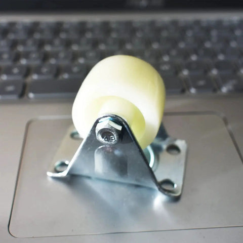 1.5 Inch PP Rigid Non Swivel Caster Wheels With Top Plates For Furniture And Workbenches on a laptop keyboard