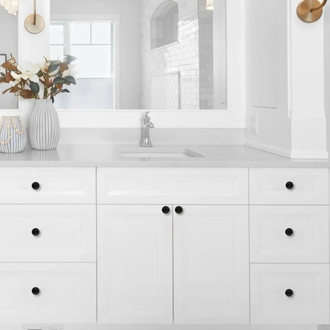 Matte black cabinet knobs on white bathroom cabinet, showcasing the 10 Pack 1-1/5 Inch (30mm) Cabinet Knobs Matte Black.