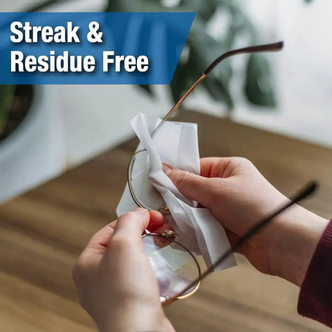 Hands using Anti-Fog And Anti-Static Lens Wipes For Glasses In Pre-Moistened Packets to clean eyewear, showing streak-free results.