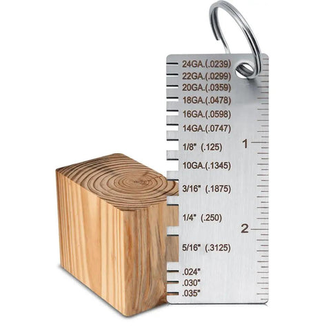 Stainless Steel Thickness Gauge For Welding And Metal Fabrication Pro Grade DIY Friendly Tool Measures 24GA to 14GA next to a wooden block.