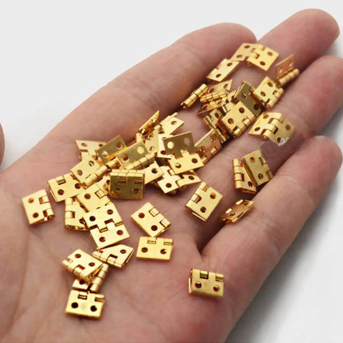 Mini Copper Hinges Set For Wooden Boxes 30 Pieces 8 By 10 Millimeter Tiny Hinges For Crafts Jewelry Boxes shown on hand