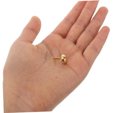 Versatile Craft Kit 100 Pcs Round Mushroom Brads And Mini Paper Fasteners in hand, showing golden metal brad fastener size and detail.