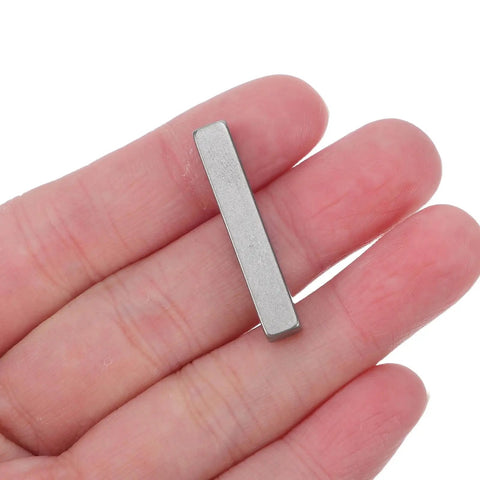 Person holding one piece of 20 Pieces Parallel Drive Shaft Keys Set, Pro Grade Stainless Steel Keyways For Secure Fastening, 3 x 0.5 cm