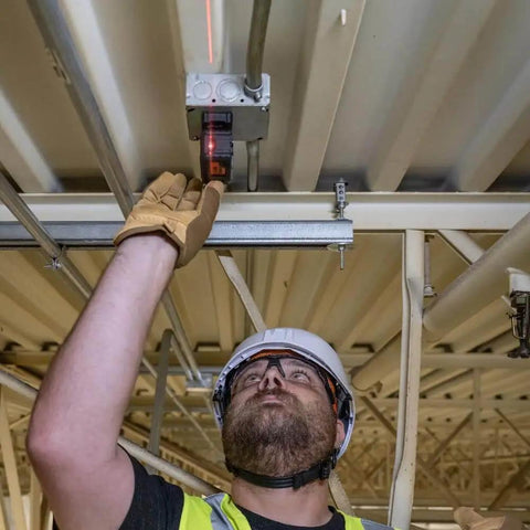 Man using Magnetic Pocket Laser Level With 360 Degree Wall Attachment, Red Laser Line Reaches 30 Feet, 3 Bubble Vials for ceiling alignment.