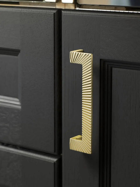 Five Pack Gold Cabinet Pulls 5 Inch Center To Center Brushed Brass Drawer Handles for bathroom cabinets, black door view.