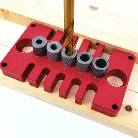 3-In-1 Dowel Jig Drill Guide Block for Woodworking in red aluminum, drilling precise dowel holes with metal bushings on wood