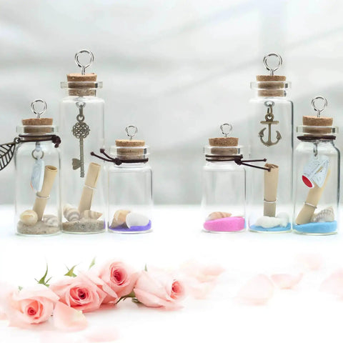 Glass bottles with cork tops and All Purpose Screw Eye Pins Set For Jewelry Making, 700pcs, showcasing keys and anchor charms on white background.
