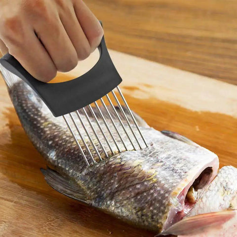 Hand holding onion holder slicer with stainless steel prongs, pinning fish on wooden cutting board, part of Crinkle Cutter Knife Set YuCool With Onion Holder Slicers Stainless Steel Kitchen Tool for Quick Slicing of Onions Potatoes Cucumbers Carrots and More Includes 1 Crinkle Knife and 2 Onion Holder Slicers.