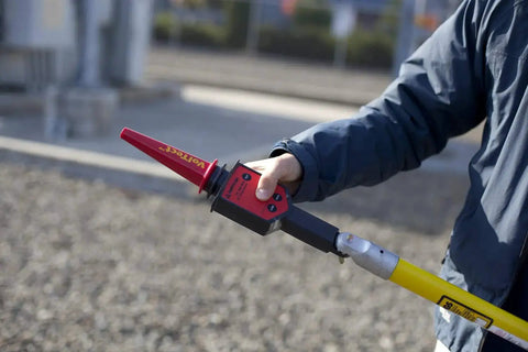 Field tech using High Voltage Detector Kit For Field Techs 30 V To 122 kV AC Intrinsically Safe Pro Grade MSHA Certified Push Button Self Test Hot Stick Included Amprobe TIC 300 PRO For Transmission Lines And Power Distribution Equipment.