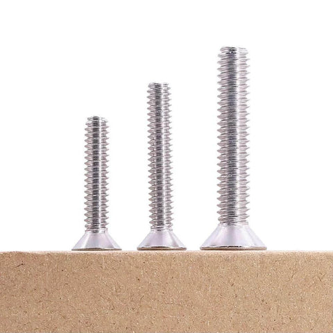 Three sizes of 1/4-20 Flat Socket Cap Screws, 2-1/2 Inch Long, Full Thread, Countersunk Head, 304 Stainless Steel 18-8 on a wooden surface