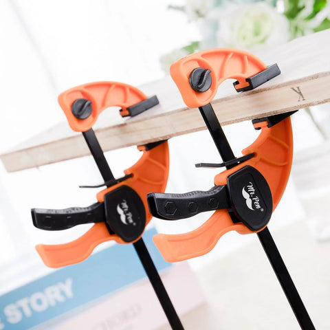 Mr. Pen 6-inch bar clamps for woodworking, orange with black quick-grip handles securing a wooden board (2-pack)